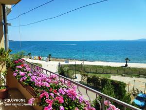 un balcón con flores y el océano en el fondo en Homestay Kostadinov en Pomorie