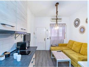 a living room with a yellow couch and a kitchen at Apartamento Mar in Aguadulce