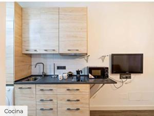 TV y cocina con fregadero y microondas. en Apartamento Mar, en Aguadulce