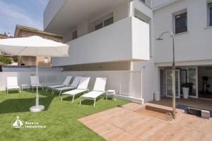 a group of chairs and an umbrella on a lawn at Residence Bafjle 42 in Lido di Jesolo