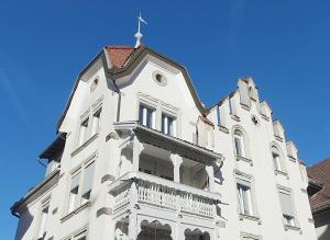 un edificio blanco con una cruz encima en Stilvoll Gertrud Schlössli 1 Zi Studio, en St. Gallen
