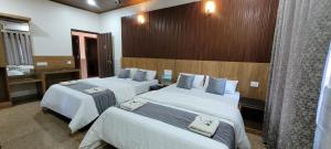 a hotel room with two beds and a bathroom at Deva Samudra Beach Stay in Gokarna