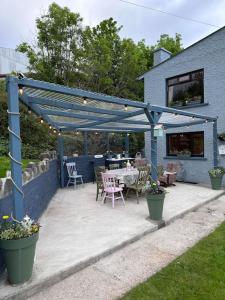 a patio with a table and chairs under a pergola at Memory Lane Farmhouse Carlingford in Lubhaidh