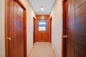a hallway with wooden doors and a tile floor at Super Townhouse 865 Edasserys Sea Pearl in Ernakulam