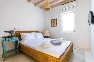 a bedroom with a bed with a table and a window at Sea View Villa in Ornos in Ornos