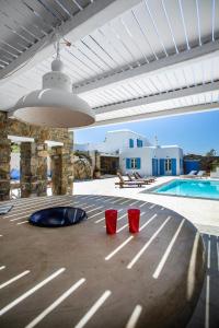 2 tazas rojas sentadas en un patio con piscina en Sea View Villa in Ornos en Ornos