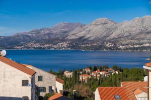 uitzicht op een stad met een meer en bergen bij Apartments Senjo in Cavtat