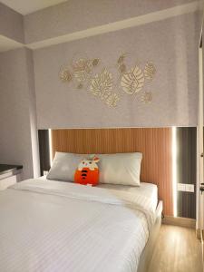 uma cama com um bicho de peluche sentado em cima dela em Newly renovated apartement @ collins boulevard em Warungmangga