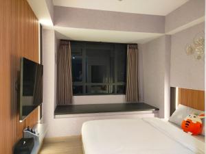 um quarto de hotel com uma cama e uma janela em Newly renovated apartement @ collins boulevard em Warungmangga