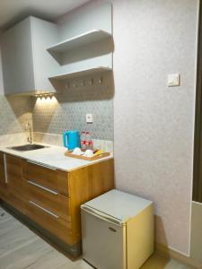 uma pequena cozinha com um lavatório e uma máquina de lavar louça em Newly renovated apartement @ collins boulevard em Warungmangga
