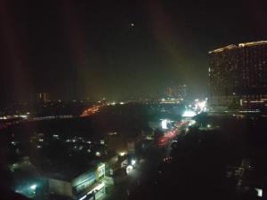 uma cidade à noite com edifícios e luzes em Newly renovated apartement @ collins boulevard em Warungmangga