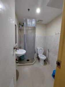 a bathroom with a toilet and a shower and a sink at Seawind Condo Tower 3,4,5,6 near Davao Airport in Davao City