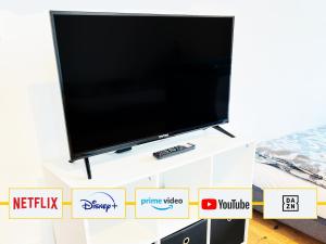 a flat screen tv on a white stand in a living room at GÜNSTIGE PREMIUM UNTERKUNFT in KÖLN - HÜRTH! in Hürth