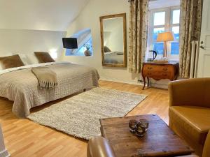 a bedroom with a bed and a mirror and a table at Anita på Gästis i Anderslöv in Anderslöv