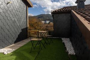 a patio with a table and chairs on a roof at Moniz Terrace in Guimarães