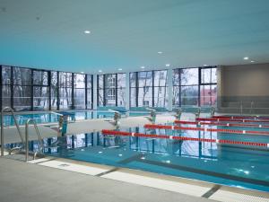 una gran piscina en un edificio con ventanas en NUUMIS luxury 115 m2 Apartment, Dresdner Heide mit Garten, en Dresden
