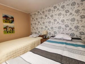 2 camas en una habitación con papel pintado floral en Montafé Mirador, en Tarma