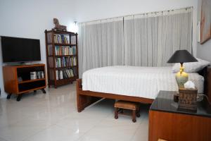 sypialnia z łóżkiem, telewizorem i stołem w obiekcie Villa Blue Lotus Katunayake w mieście Katunayake