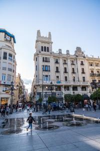 a child is playing in a fountain in a city at Tendillas Room in Córdoba