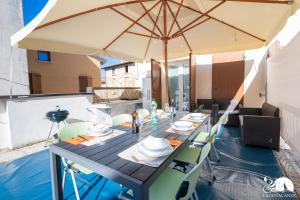 un tavolo da pranzo con ombrellone su un patio di Appartamento Lilli a Manerba del Garda