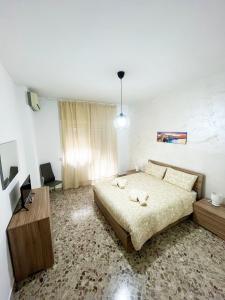 ein Schlafzimmer mit einem großen Bett und einem Holztisch in der Unterkunft La casa del sole in Bari