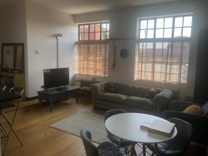 uma sala de estar com um sofá e uma mesa em Toothbrush Apartments - Central Ipswich - Lloyds Avenue em Ipswich