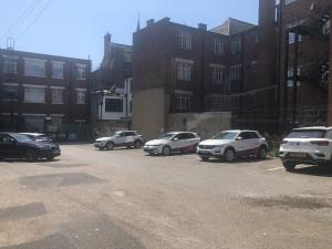 un grupo de autos estacionados en un estacionamiento en Toothbrush Apartments - Central Ipswich - Lloyds Avenue en Ipswich