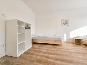 ein Schlafzimmer mit einem Bett und einem Bücherregal in der Unterkunft Tolstov Apartments - Monteurwohnungen - 2 Schlafzimmer - Küche - Balkon - Waschmaschine - 25 Min zur Messe DUS in Heiligenhaus