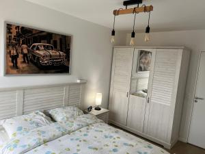 a bedroom with a bed and a picture of a car at 3 pièces à 4min du RER B in Saint-Denis