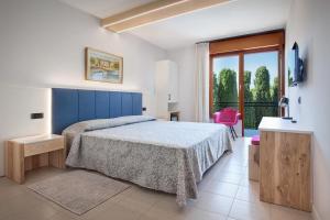 a bedroom with a bed and a large window at Hotel Gabbiano - Garda Lake Collection in Garda