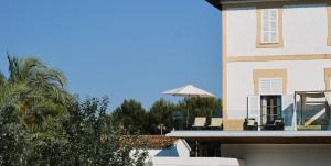 widok na budynek z krzesłami i parasolem w obiekcie Prinsotel Mal Pas w Alcudii