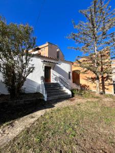 een kleine witte kerk met trappen en een boom bij Can Bastida in Cardona