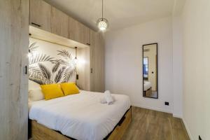 um quarto com uma cama grande e almofadas amarelas em Vivez Antibes ! Logez à 6 au centre-ville em Antibes
