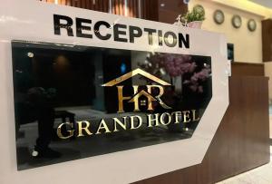 a sign for a grand hotel with a house on it at HR Grand Hotel in New Delhi