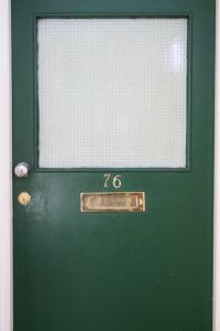 une porte verte avec une fenêtre au-dessus dans l'établissement Bright wood-floor apartment near Parliament, à Londres
