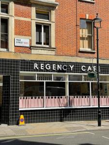 a red brick building with a recovery cafe on the street at Bright wood-floor apartment near Parliament in London