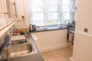 a kitchen with a stainless steel sink and a window at Bright wood-floor apartment near Parliament in London