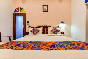 ein Schlafzimmer mit einem Bett mit einer bunten Decke darauf in der Unterkunft FabHotel Ambika Chirwa House in Udaipur