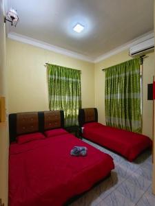 - une chambre avec 2 lits et des draps rouges dans l'établissement Perhentian Idaman, aux Îles Perhentian