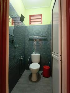 La petite salle de bains est pourvue d'une douche et de toilettes. dans l'établissement Perhentian Idaman, aux Îles Perhentian