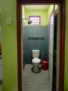 Elle comprend une petite salle de bains pourvue de toilettes et d'une fenêtre. dans l'établissement Perhentian Idaman, aux Îles Perhentian