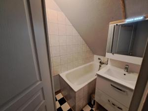 uma pequena casa de banho com um lavatório e uma banheira em Atypique et douillet nid em Vougeot