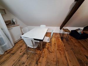 uma mesa e cadeiras num quarto com piso em madeira em Atypique et douillet nid em Vougeot