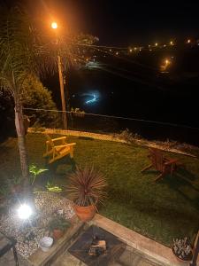 a garden at night with a table and benches at Emiliadourohouse in Marco de Canaveses
