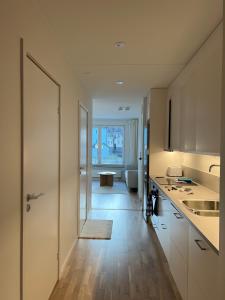 a kitchen with a door leading to a living room at Cozy apartment 2 stops-15 mins away from city center in Stockholm