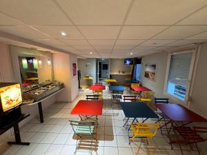 a restaurant with colorful chairs and tables in a cafeteria at Le 2 by Hotel Akena - Nantes Beaujoire, Porte de Sainte Luce in Sainte-Luce-sur-Loire +20 photos