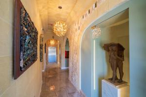 a hallway with a statue and chandeliers in a house at L-Eremita Boutique Hotel in Qala