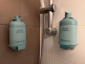 two bottles of shampoo on a bathroom wall at Le 2 by Hotel Akena - Nantes Beaujoire, Porte de Sainte Luce in Sainte-Luce-sur-Loire