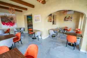 a restaurant with tables and chairs in a room at L-Eremita Boutique Hotel in Qala +37 photos