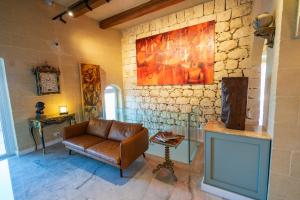a living room with a couch and a painting on the wall at L-Eremita Boutique Hotel in Qala